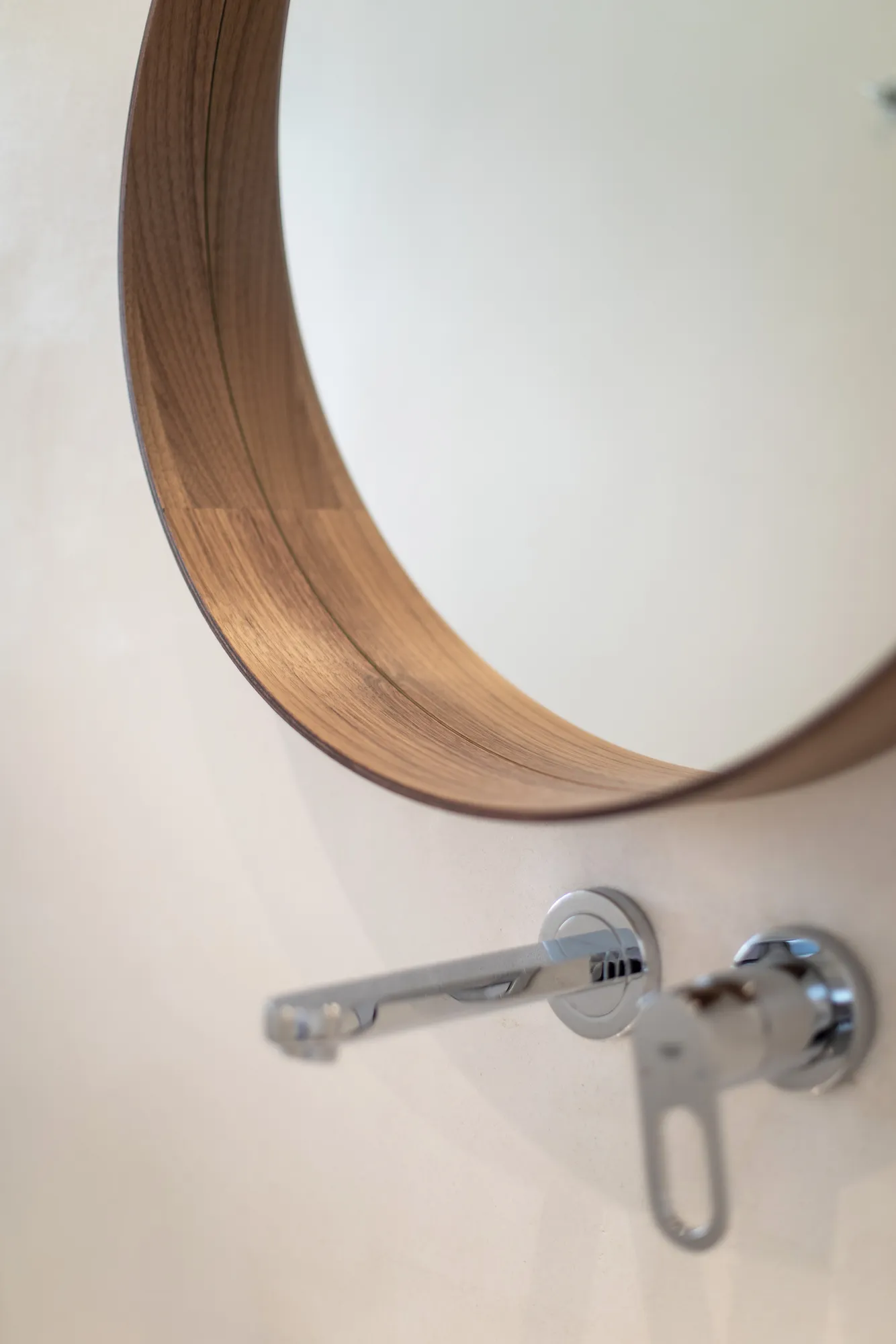 Round wooden mirror in the bathroom